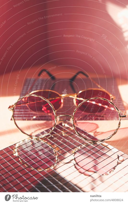 Studioaufnahme einer trendigen weiblichen Sonnenbrille in Korallen- und Rottönen für den Sommer Brille Mode trendy rosa Produkt Stillleben Spiegel retro