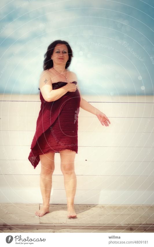 Auf dem Weg zum Bade, reife Frau, die einen Pareo als Strandkleid verwendet Sommer leicht bekleidet baden gehn barfuß Kitsch bitti nackt dunkelhaarig