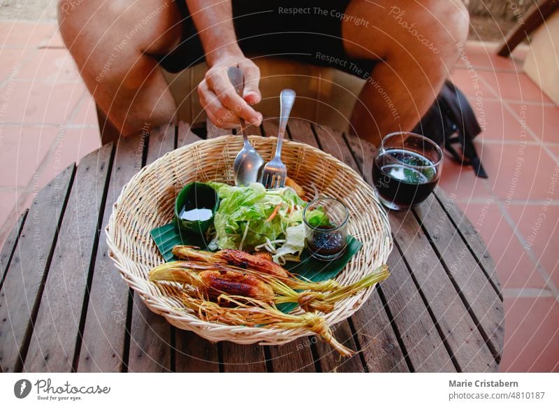Touristen essen die kambodschanische Version von Rindfleischspießen mit Zitronengras oder Bo Xa Nuong aus Vietnam Feinschmecker Ernährungstourismus