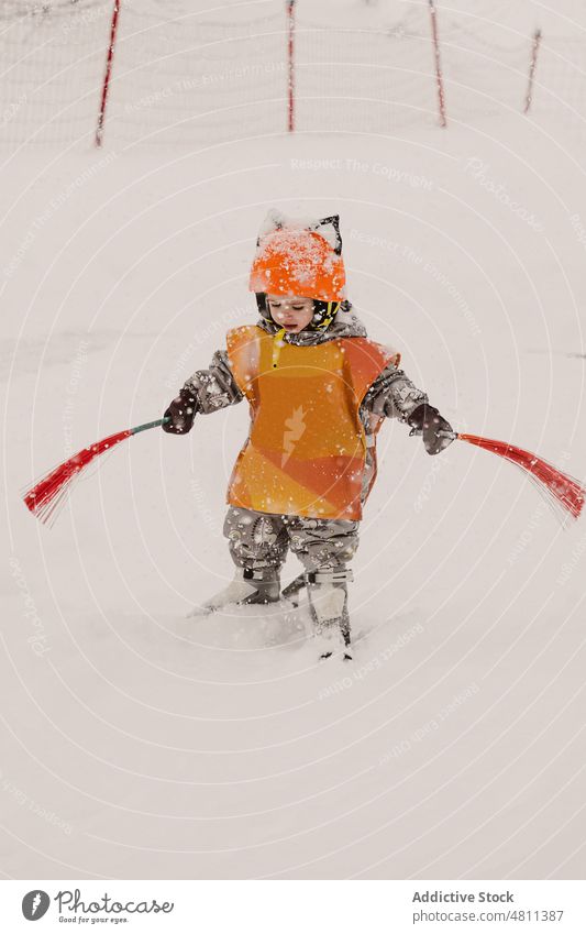 Aufmerksames kleines Kind mit Pinseln, das auf Skiern in verschneitem Gelände balanciert üben Winter Skigebiet achtsam Schnee Gleichgewicht Bürste Sport