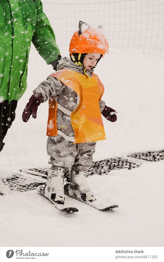 Entzückendes Kind balanciert auf der Piste während des Skiunterrichts üben Schnee Gleichgewicht Aktivität lernen Berge u. Gebirge Winter Training Ausbilderin