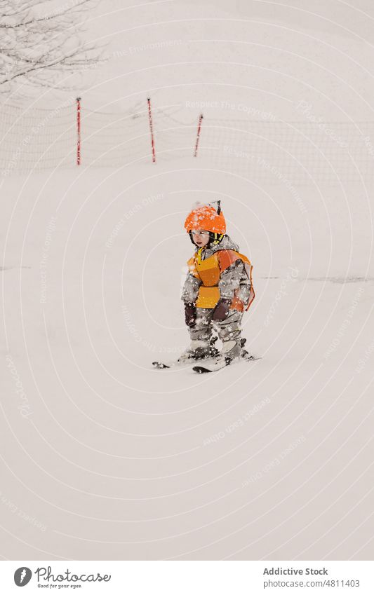 Niedliches Kind übt Skifahren an einem Wintertag üben Skigebiet Schnee Training Aktivität Sport aktiv Skifahrer Mädchen Schutzhelm Mut Kleinkind Oberbekleidung