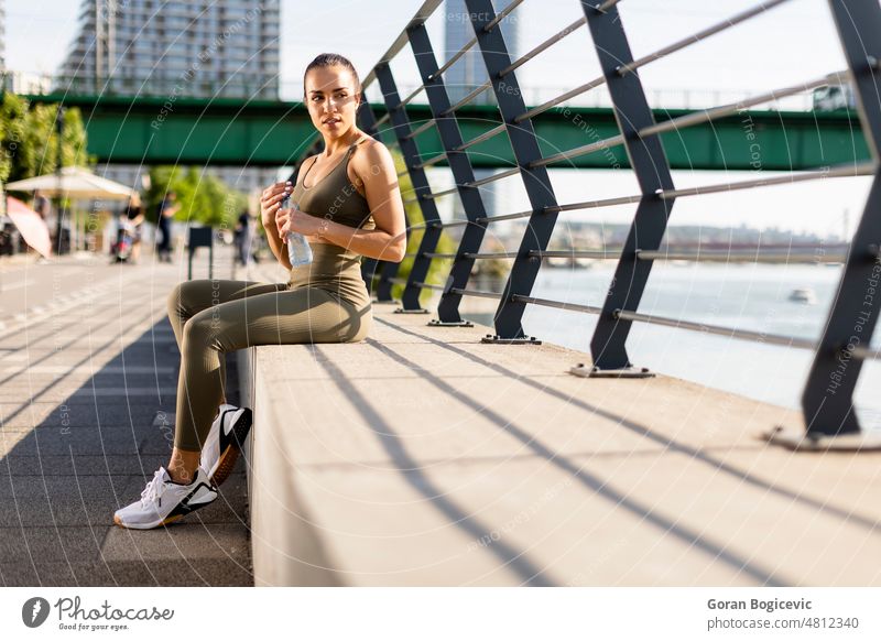 Junge Frau macht eine Pause beim Sport an der Flusspromenade aktiv Erwachsener arabisch Athlet sportlich Schönheit Nahaufnahme trinken Übung passen Fitness