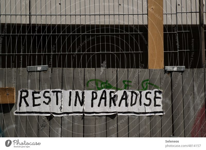 Rest in Paradise Graffiti Plakat Plakatwand Baustelle Menschenleer Außenaufnahme kaputt Paradies Schriftzeichen trashig Schilder & Markierungen Stadt