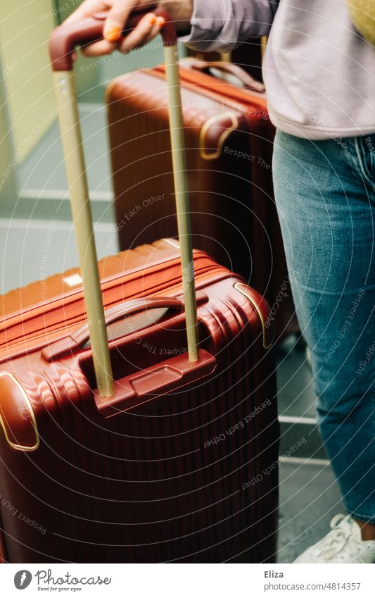 Frau mit Reisekoffer im Aufzug Koffer Reisen Ferien & Urlaub & Reisen verreisen Gepäck Reisende beerenfarben rot dunkelrot Jeans