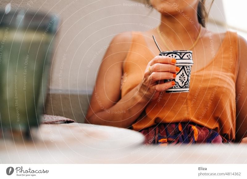 Frau mit Kaffeetasse sitzt im Sommer draußen im Café sitzen Kaffeetrinken Tisch anonym warm Kaffeepause Gastronomie
