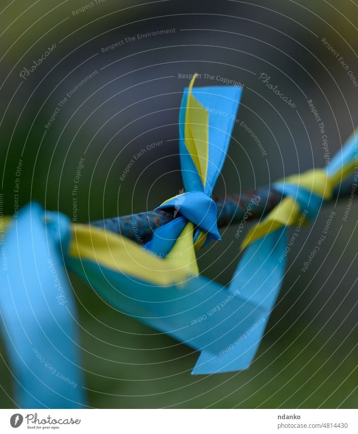 blaues und gelbes Seidenband, das auf ein Metallrohr gebunden ist. Symbol der ukrainischen Flagge, Kampf für die Unabhängigkeit Ukraine Fahne Ukrainer Freiheit