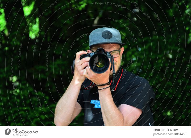 [Hansa BER 2022] Shooting! Fotograf mit Brille und Cap, Kamera mit mächtigem Objektiv im Anschlag, Finger am Auslöser bei der Gegenwehr oder - wer hat angefangen?