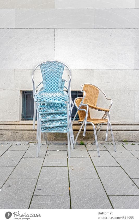 Gestapelte Stühle vor Café Korbstuhl Stuhl sitzen aufräumen Sitzgelegenheit hellblau Menschenleer Sessel Einsamkeit traurig geschloßen Möbel geschlossen