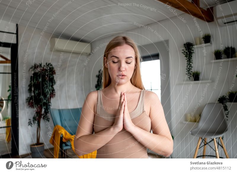 Blonde Frau. Mädchen mit geschlossenen Augen gefalteten Händen in Namaste Geste und meditiert in Yoga-Klasse Mental Health Pflege Wellness Myofascial Entspannung
