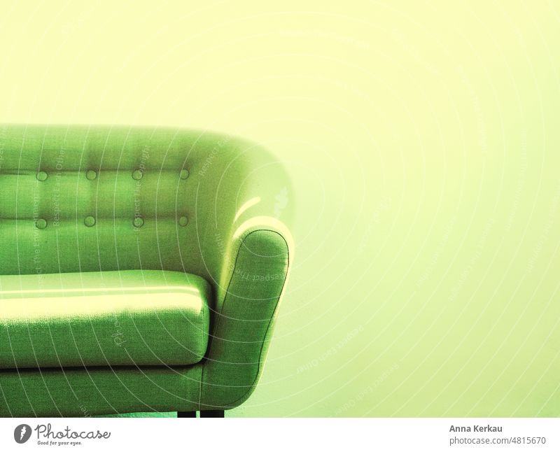 Ein sonnenbeschienenes grünes Sofa steht vor einer grünlich-gelben Wand Licht Pause Sitzmöbel stylisch Gemütlichkeit Wohnzimmer leuchtende Farben Möbel