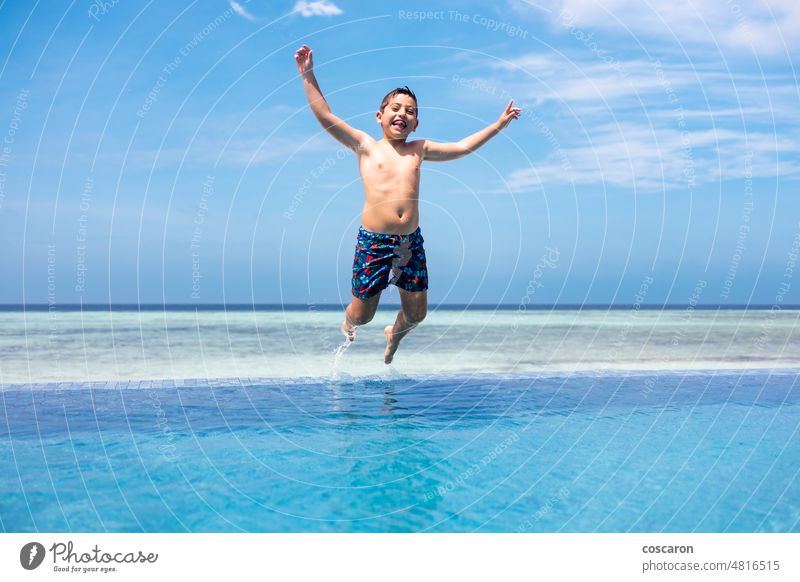 Lustiges Kind springt in einen Infinity-Pool aktiv Baby blau Blauer Himmel Junge Familie Spaß lustig Fröhlichkeit Glück Feiertag Hotel Unendlichkeit Insel