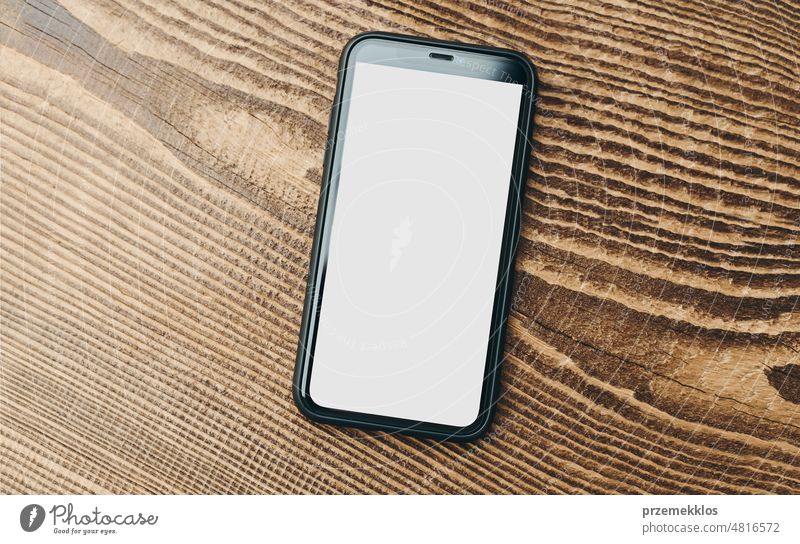 Smartphone Mockup mit soliden weißen Farbe leeren leeren Bildschirm auf hölzernen Hintergrund isoliert. Schwarzes Handy oben Ansicht flach legen mit Kopie Raum. Platz für Text