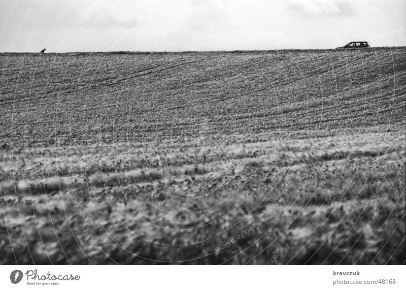 Auto sucht Herrchen Feld Landwirtschaft Hügel Wolken Querformat horizontal Einsamkeit gebeugt PKW Getreide Himmel Schwarzweißfoto Bodenbelag Bodenerhebung