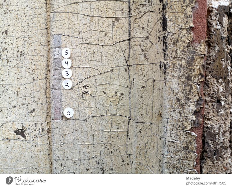 rundepapieraufkleber mit handgeschriebenen Zahlen am Türrahmen eines alten leerstehenden Haus im Stadtteil Sachsenhausen in Frankfurt am Main in Hessen Wand