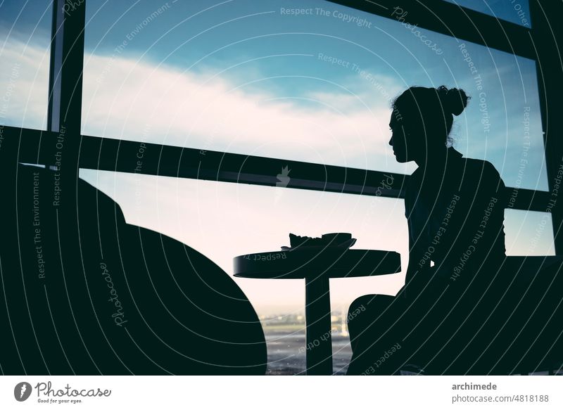 Frau wartet in der Flughafenlounge reisen Reise räkeln Warten Silhouette Abflüge Ankunft Hostess Tisch Sitz Sitzen Lifestyle Verkehr Transport reisend Fenster