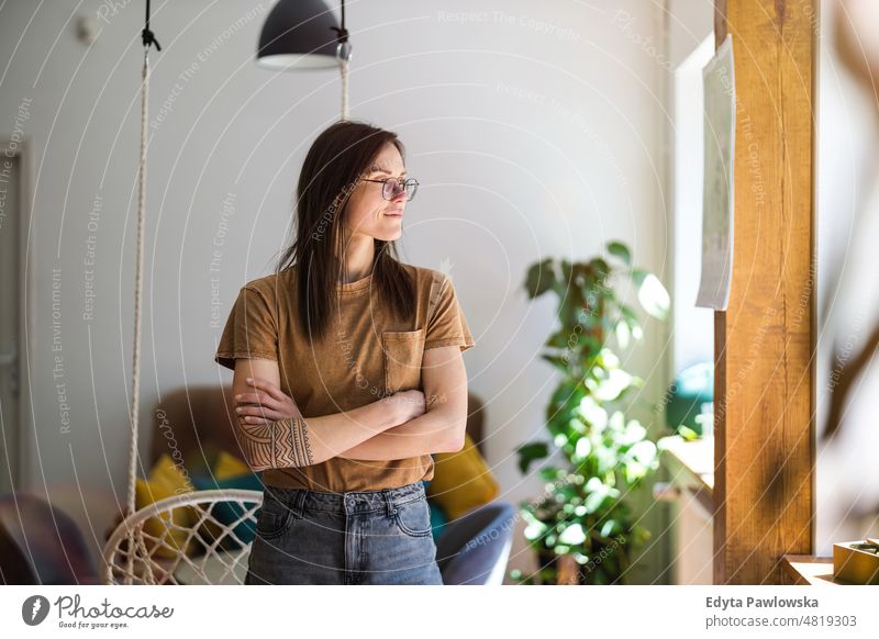 Porträt einer jungen Frau, die in ihrer Wohnung steht häusliches Leben Selbstvertrauen im Innenbereich heimwärts Haus Menschen Erwachsener lässig Kaukasier
