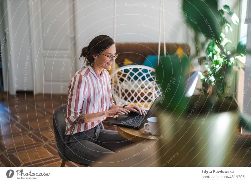 Junge Frau benutzt einen Laptop zu Hause häusliches Leben Selbstvertrauen im Innenbereich heimwärts Menschen jung Erwachsener lässig Kaukasier attraktiv schön