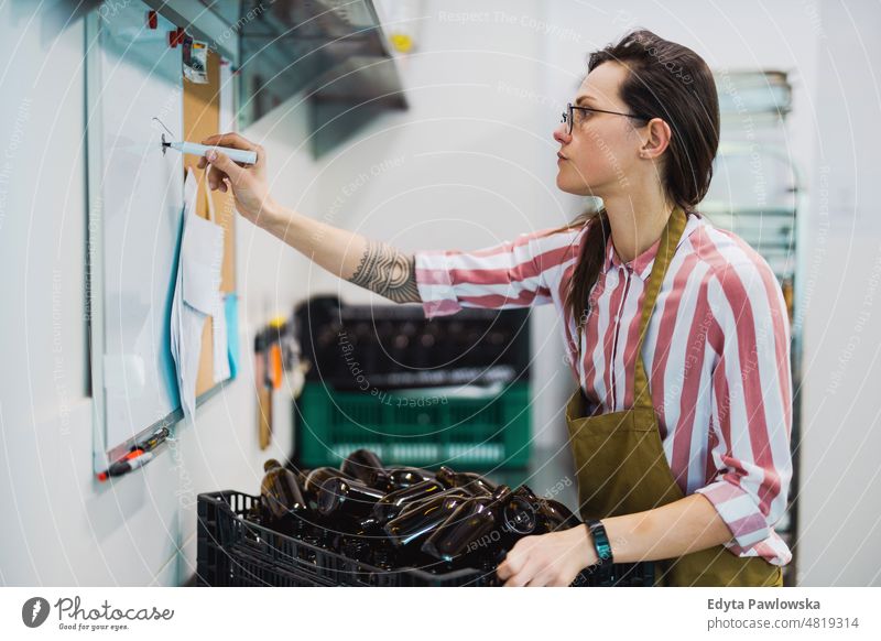 Frau, die in einem kleinen Unternehmen der Lebensmittelindustrie arbeitet Schürze arbeiten Arbeiter Fabrik Inszenierung Mitarbeiter Fähigkeit Personal