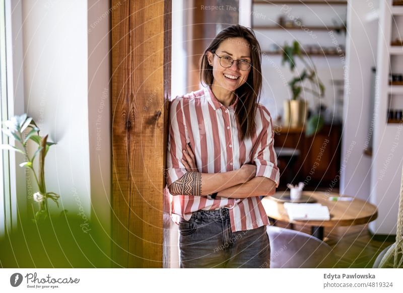 Porträt einer jungen Frau, die in ihrer Wohnung steht häusliches Leben Selbstvertrauen im Innenbereich heimwärts Haus Menschen Erwachsener lässig Kaukasier