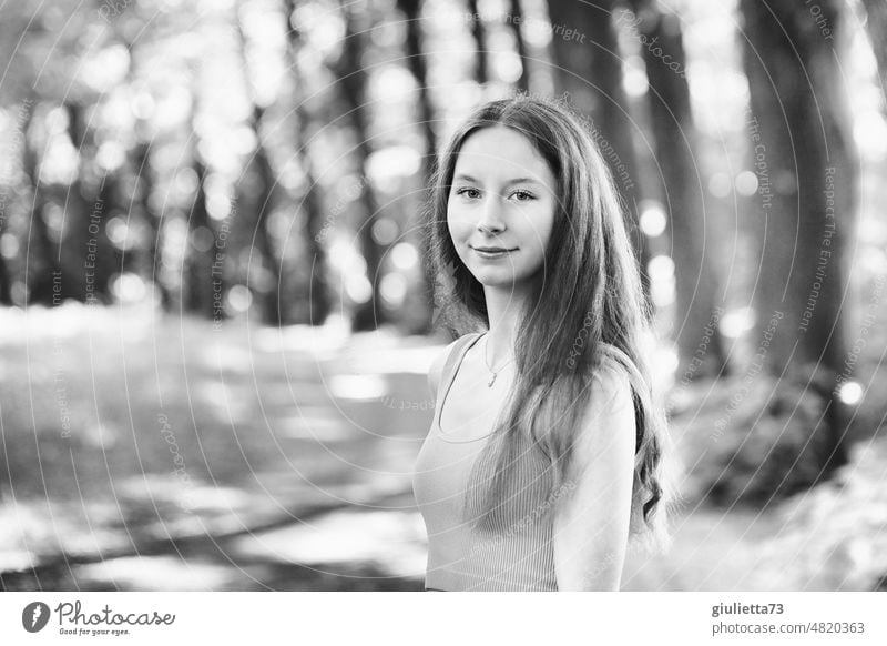 Sommerliches schwarz-weiß-Porträt eines langhaarigen Teenager Mädchens im Park Gegenlichtportrait naturliebend Mensch Mai Juli jung Blick Schwache Tiefenschärfe
