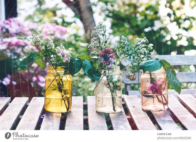 Abendstimmung im Garten, auf dem Tisch drei Vasen mit verlorenen Blüten Blumen draußen zart vergänglich Frühling Sommer Licht Farben farbenfroh
