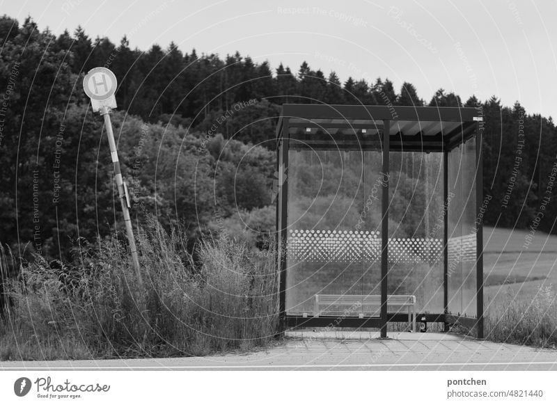 Landleben. Eine verlassene Bushaltestelle. Schiefes haltestellenschild. Schwarz-weiß. Öffentlicher nahverkehr öffentlicher nahverkehr landleben schief
