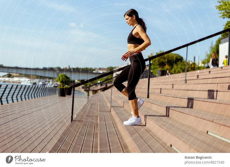Junge Frau in Sportkleidung beim Training an einer Flusspromenade aktiv sportlich schön Kaukasier Energie Übung passen Fitness Flexibilität Gesundheit Jogger