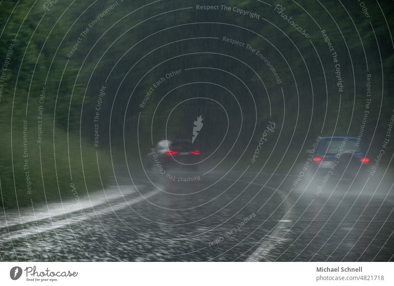 Straßenverkehr im starken Regen starker Regen Starkregen lichter autos Autolichter Vorsicht Wetter nass Wasser schlechtes Wetter Wassertropfen grau Rücklichter