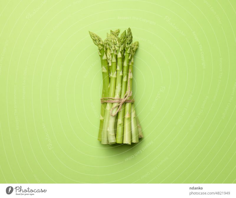 Strauß frischer roher Spargel auf grünem Papierhintergrund, Ansicht von oben Bestandteil Lebensmittel Gemüse Vegetarier organisch Diät Haufen Gesundheit