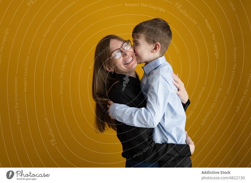 Liebevolle Mutter umarmt glücklichen Sohn Kuss Umarmung Glück Lächeln heimwärts Zusammensein Partnerschaft Porträt Frau Junge smart lässig hell Brille positiv