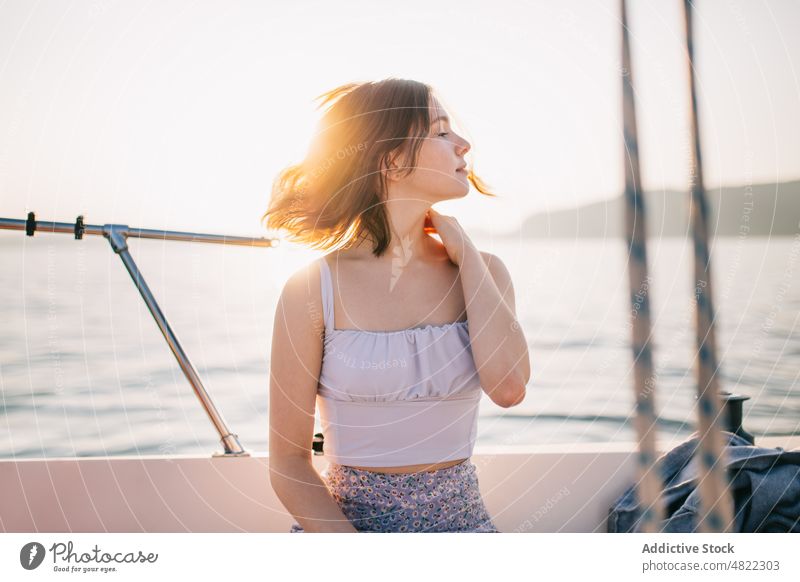 Ruhige junge Frau bewundert die Natur, während sie auf einem Segelboot steht MEER Jacht bewundern Feiertag Kreuzfahrt Sommer Urlaub Porträt trendy Stil Ausflug