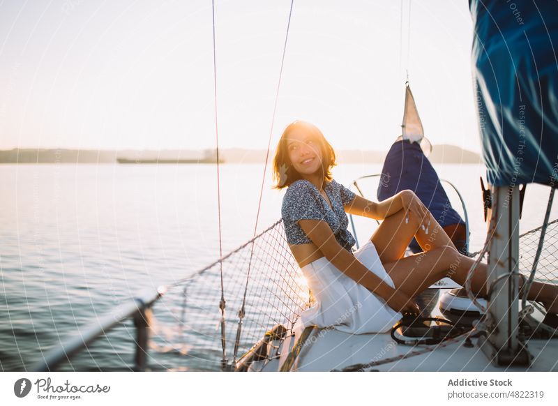 Stilvolle Touristin, die sich auf einer Yacht ausruht und wegschaut Frau bewundern MEER Segelboot Reisender Sonnenuntergang Urlaub Kreuzfahrt Feiertag Porträt