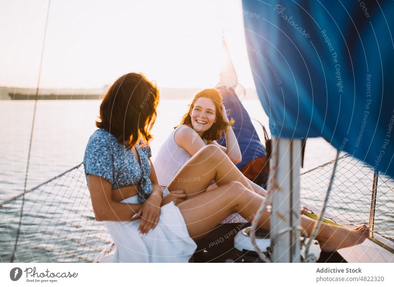 Glückliche Frauen unterhalten sich während einer Kreuzfahrt auf dem Meer bei Sonnenuntergang Segelboot Freund MEER Sommer Urlaub Zusammensein Jacht Lächeln
