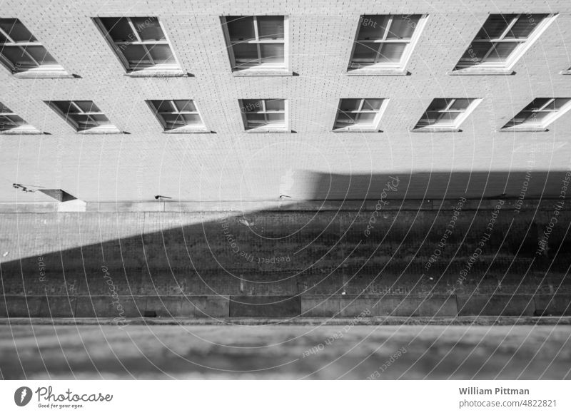 Leiste bnw Schwarzweißfoto Felsüberhang herabsehend Außenaufnahme Gebäude Menschenleer