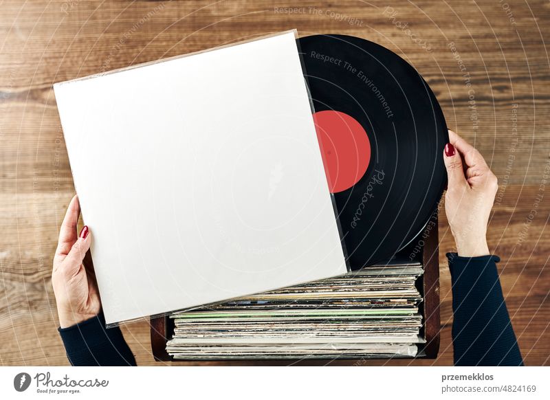 Abspielen von Vinyl-Schallplatten. Hören von Musik aus Vinyl-Schallplattenspieler. Retro- und Vintage-Musikstil. Frau hält analoges LP-Album. Musik Leidenschaft