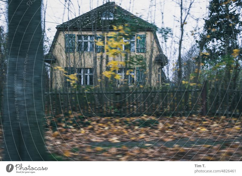ein altes Haus hinter einem Holzzaun im Herbst Zaun Außenaufnahme Menschenleer Tag Farbfoto Gebäude randberlin Architektur Bauwerk trist Baum Fassade Wand