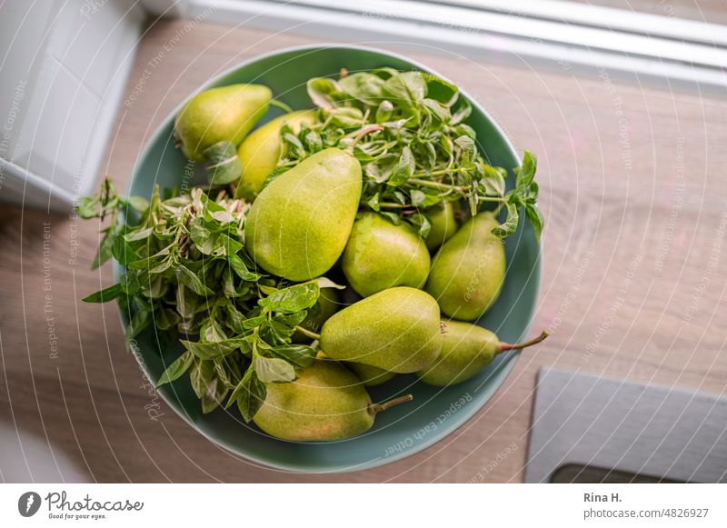 Birnen und Basilikum in einer Schale am Küchenfenster Obst Bioprodukte Bioobst Gartenfrüchte Obstschale