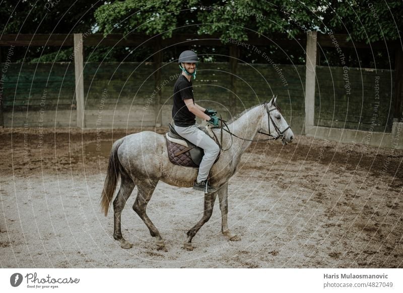 Mann reitet Pferd auf der Koppel Tier schön züchten heimisch Reiterin schnell Zaun Freiheit Spaß galoppieren glühend grün Reiten Reithelm Pferderücken Jockey