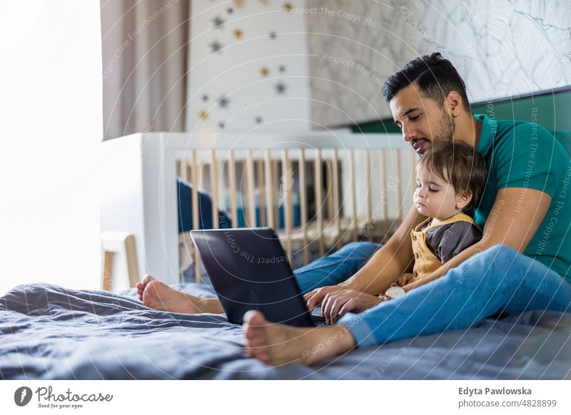 Junger Mann und sein Sohn benutzen einen Laptop zu Hause Erwachsener Zuneigung Baby Bonden offen Pflege Kind Kindheit heimisch genießend Familie Spaß