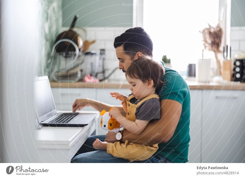 Vater arbeitet am Laptop mit Kind auf dem Schoß Erwachsener Zuneigung Baby Bonden Junge offen Pflege Kindheit heimisch genießend Familie Spaß Fröhlichkeit Glück