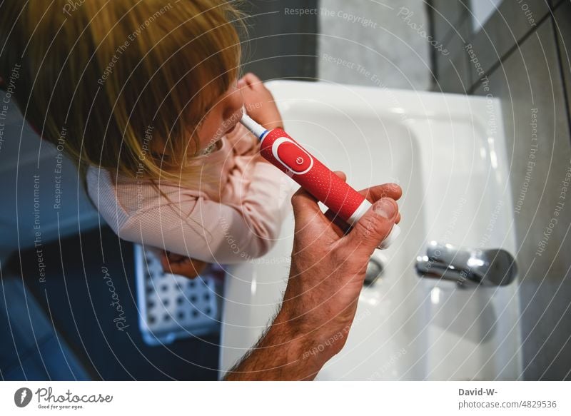 Vater putzt Kind die Zähne Zähneputzen Verantwortung Zahnbürste Zahnpflege Hände Badezimmer Waschbecken