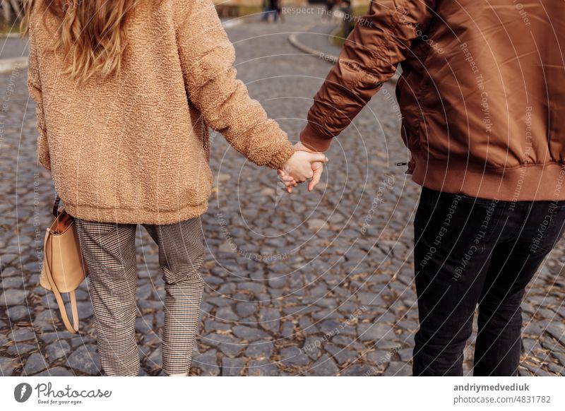 Ausgeschnittenes Foto eines jungen Liebespaares, das im Freien spazieren geht und sich an den Händen hält. Paar laufen Beteiligung andere abgeschnitten jeder