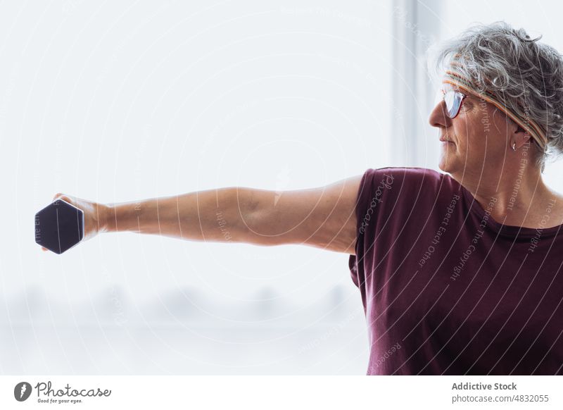 Anonyme ältere Frau beim Training mit Hanteln Übung Kurzhantel Fitness Gewichtheben heimwärts Morgen üben Ausdauer Senior gealtert Rentnerin
