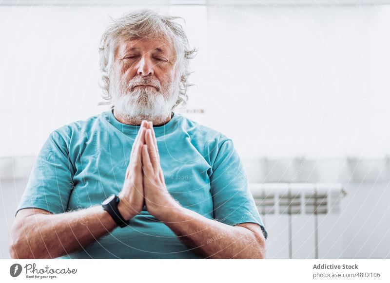 Entspannter älterer Mann beim Meditieren am Morgen meditieren heimwärts sich[Akk] entspannen Yoga Sitzung Namaste üben Windstille männlich Senior gealtert