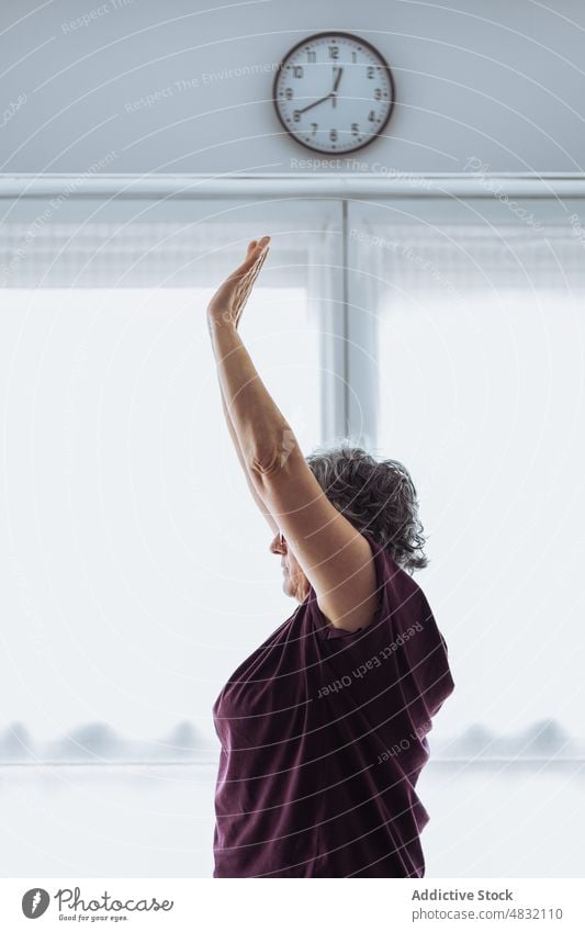 Ältere Frau beim morgendlichen Sport Übung Dehnung Morgen heimwärts gymnastisch Arm angehoben Training früh Fitness älter Senior gealtert sonnenbeschienen