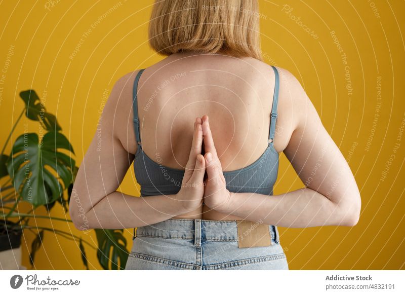Anonyme Frau, die im Studio die Yoga-Pose des umgekehrten Gebets einnimmt Umgekehrtes Gebet Yoga Paschim Namaskarasana Asana Stressabbau meditieren Zen
