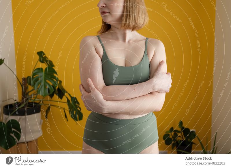 Anonyme kurvige Dame mit verschränkten Armen in der Nähe einer gelben Wand stehend Frau körperpositiv Übergröße Model Figur natürlich Persönlichkeit