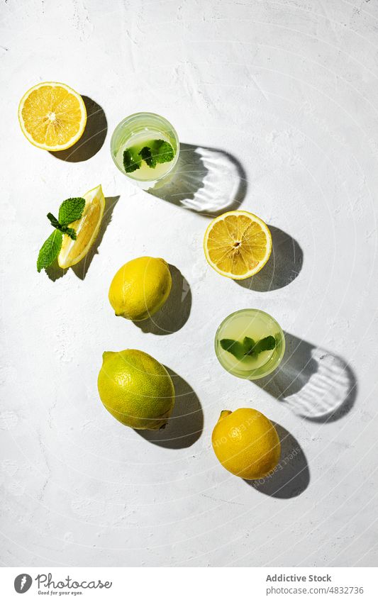 Flachlegung des Sommerkonzepts Konzept Zusammensetzung Zitrone frisch natürlich Gesundheit organisch Brille Getränke gelb Schatten Sonnenlicht Minze hell Frucht
