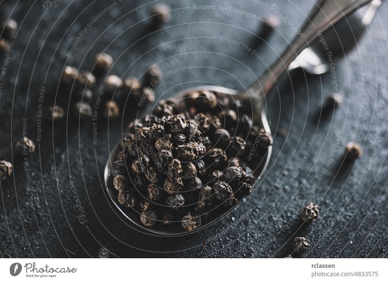 Schwarze Pfefferkörner auf einem Löffel Paprika schwarz Gewürz Boden Pulver weiß Aroma aromatisch Schalen & Schüsseln Mais trocknen explodierend Geschmack